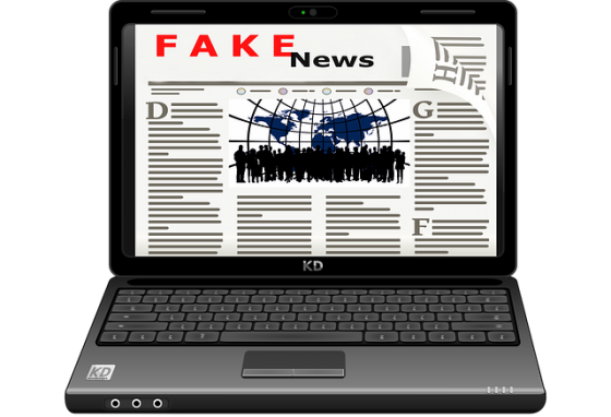 A laptop open showing Fake News as the headline