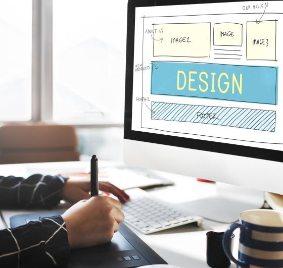 A person drawing on a computer, laying out a website design concept