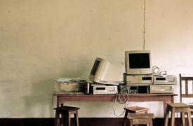 A pile of old computers stacked up on a desk