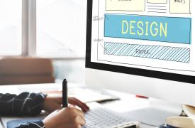 A person drawing on a computer, laying out a website design concept