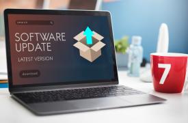 Photograph of a laptop screen displaying a software update notification and a download button.